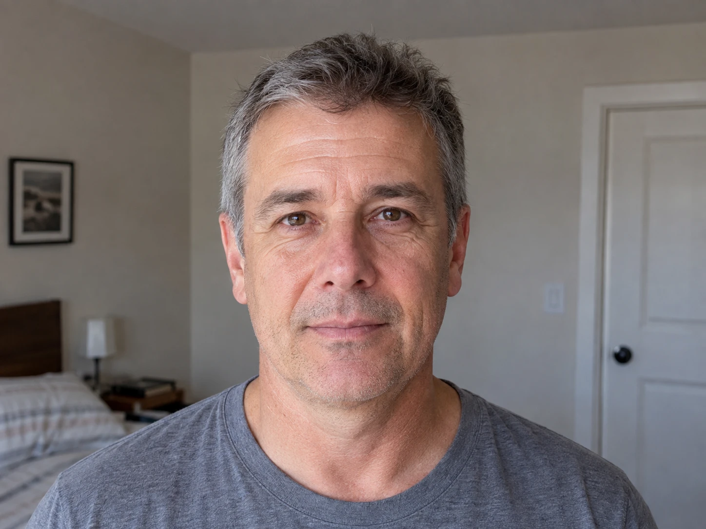 A straight front view of a man's hairline and short gray and brown hair