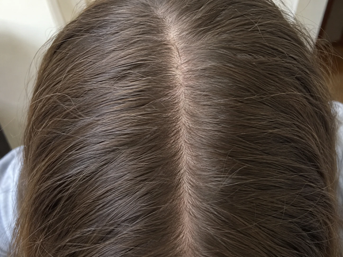 Overhead view of a natural center part in brown hair